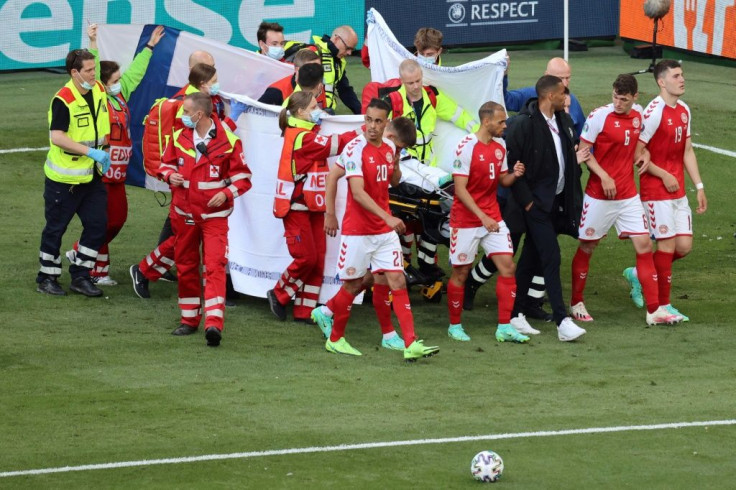 Denmark's players gather as medics treat midfielder Christian Eriksen during the Euro 2020 match against Finland
