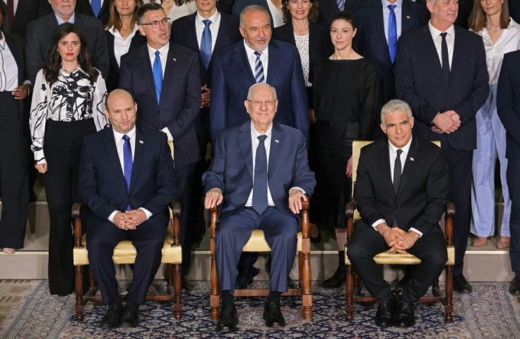 Israeli President Reuvin Rivlin (C) is flanked by Prime Minister Naftali Bennett (L) and alternate Prime Minister and Foreign Minister Yair Lapid and their new coalition government at the president's residence in Jerusalem, on June 14, 2021