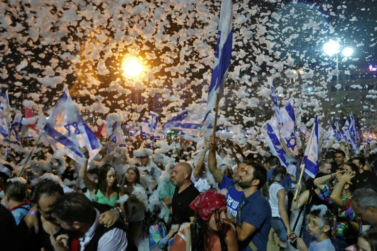 Israelis celebrate the passing of a Knesset vote confirming a new coalition government during a rally in coastal city of Tel Aviv on June 13, 2021