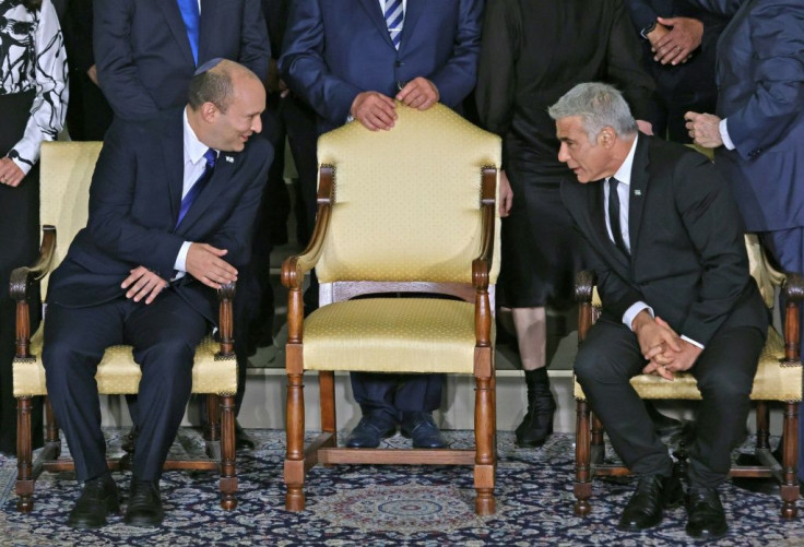 Israeli Prime Minister Naftali Bennett (L) and alternate Prime Minister and Foreign Minister Yair Lapid chat ahead of a photo session at the president's residence in Jerusalem on June 14, 2021