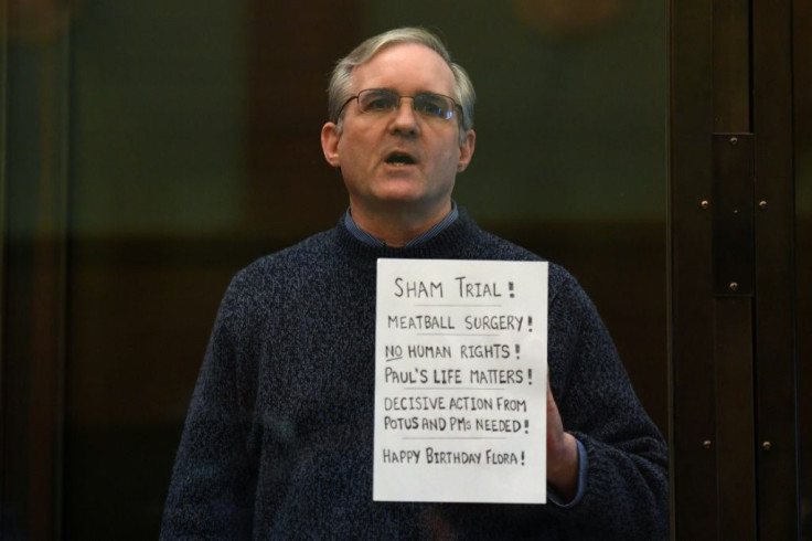 Paul Whelan, a former US Marine accused of espionage, holds a written protest from a defendants' cage at a Moscow court in June 2020