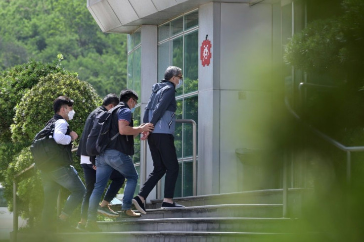 Cheung Kim Hung, CEO and Executive Director of Next Digital Ltd, is escorted by police into the Apple Daily newspaper offices in Hong Kong