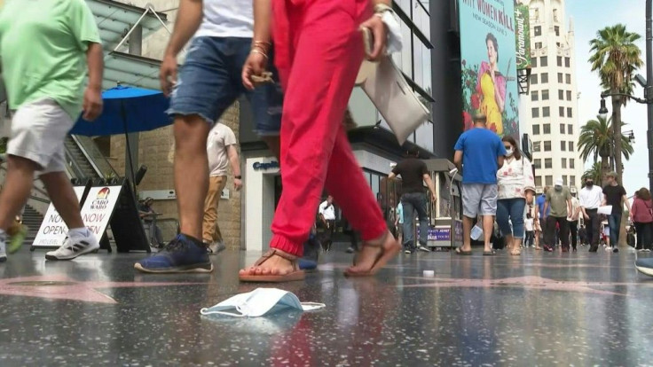 People walk down Hollywood Boulevard in Los Angeles as California -- the first US state to enact a stay-at-home order just under 15 months ago -- celebrates its "reopening day" by lifting almost all pandemic-related social distancing and capacity limits. 