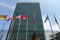 A person walks past flags outside the United Nations headquarters on May 20, 2021 in New York