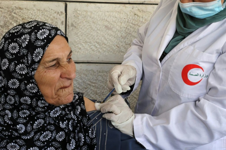 A mobile Covid inoculation unit vaccinates an elderly Palestinian in the village of Dura in the Israeli-occupied West Bank