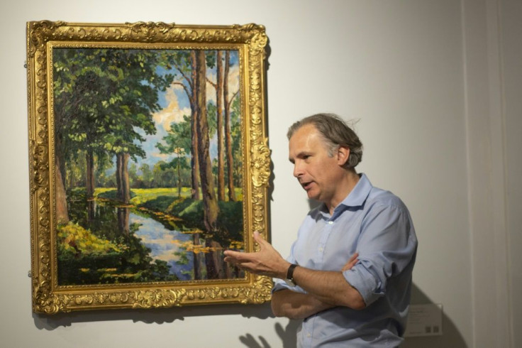 Jean-Paul Engelen, Deputy Chairman of Phillips auction house, speaks next to "The Moat, Breccles" painting by Winston Churchill and owned by the Onassis family