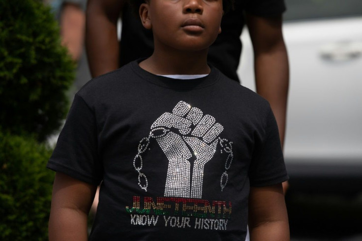 A boy listens to live Go-Go music playing at Black Lives Matter Plaza in Washington, DC, on June 19, 2021, during a Juneteenth celebration