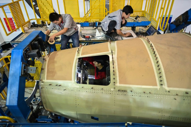Employees work on an aft fuselage section of a C919