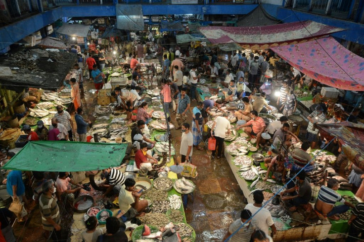 People shop at a fish market in Kolkata after the state government in India's West Bengal eased lockdown restrictions