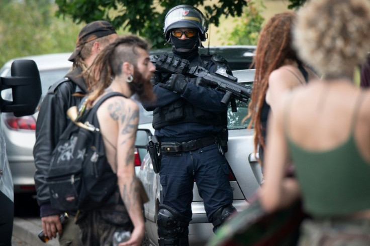 An officer looks on as police evacuate partygoers after an illegal rave in a field in Redon, France