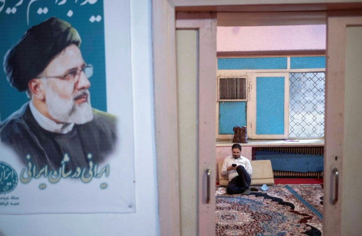 A supporter of Iranian President-elect Ebrahim Raisi checks his phone at one of his campaign offices in downtown Tehran