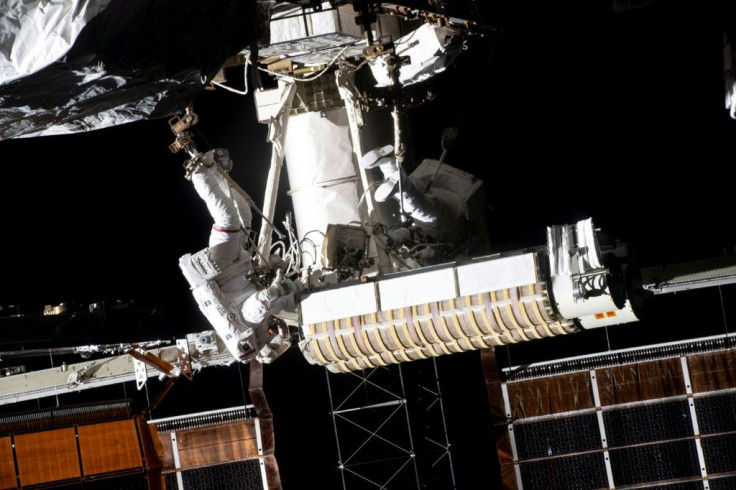 French astronaut Thomas Pesquet (L) installs a solar panel on the International Space Station on June 20, 2021