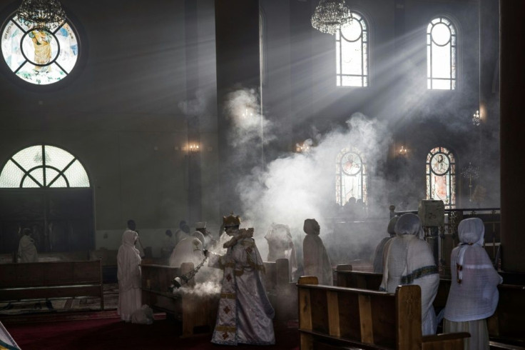 A priest wafts incense at the Bole Medhanialem Church in Addis Ababa, on June 20, 2021 during an early morning service as women congregate