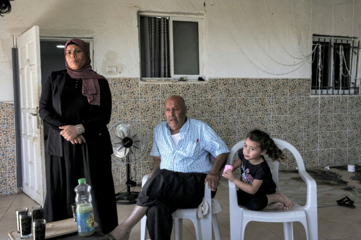 Members of the Abu Qwaider family sit together at their home in the village of Sawaneen, in Israel's southern Negev region