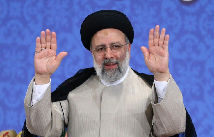 Iran's President-elect Ebrahim Raisi smiles as he greets journalists ahead of his first press conference on June 21, 2021