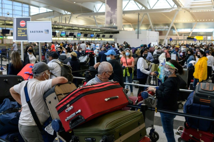 Passengers wait in line at John F. Kennedy Airport in New York on May 28, 2021 as travel resumes following the Covid pandemic