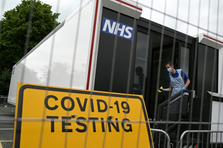A worker cleans down the doorway of a Covid-19 testing site in a car park in Penrith in Cumbria, northwest England, amid concerns over the Delta variant