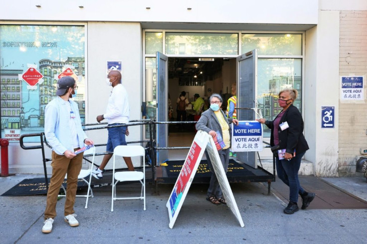 Poll workers stand outside of an early voting location on June 16, 2021 in the Upper West Side neighborhood of Manhattan in New York City