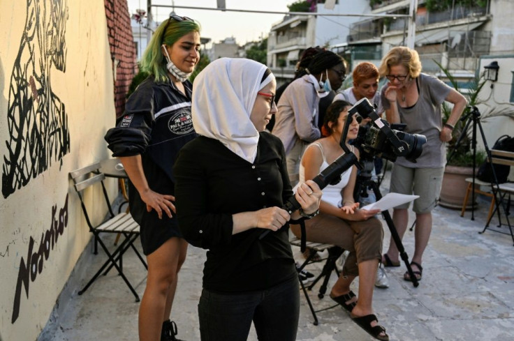 Ataa Bremo from Syria and other refugees film an interview on gender-based violence