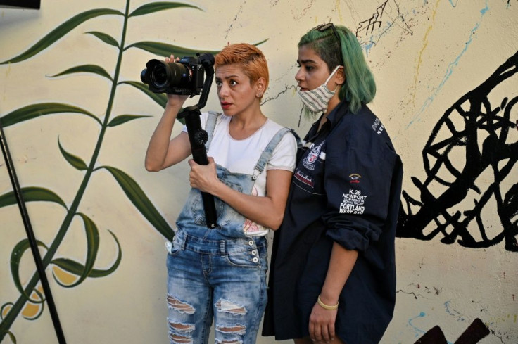 Sisters Sude (L) and Eli  Fazlolah from Iran film another interview on gender-based violence