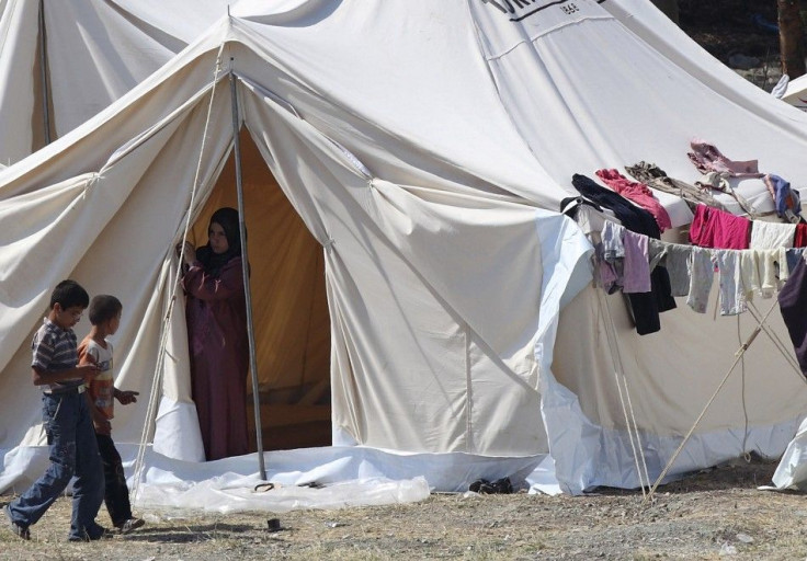 Children walk beside tents in a refugee camp in the Turkish border town of Yayladagi