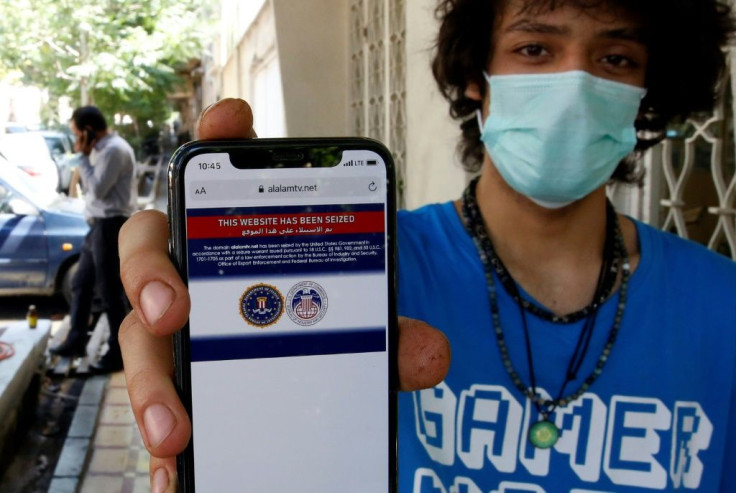 An Iranian youth shows on his mobile phone a statement declaring the website of Iran's Arabic-language channel Al-Alam has been seized by the US government