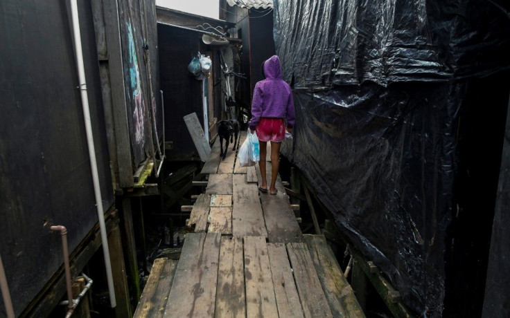 A resident walks along a platform on stilts at the Dique da Vila Gilda favela, in Santos, Sao Paulo state, Brazil, on June 10, 2021