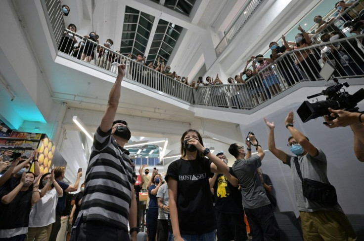 Employees, executive editor in chief Lam Man-Chung (L) and deputy chief editor Chan Pui-Man (C) cheer each other in the Apple Daily newspaper office atrium after completing the final edition of the newspaper