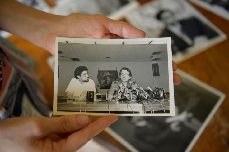 Cristian Tinoco dispays a photograph of her father Victor Hugo Tinoco (left) alongside Nicaragua President Daniel Ortega taken in 1979