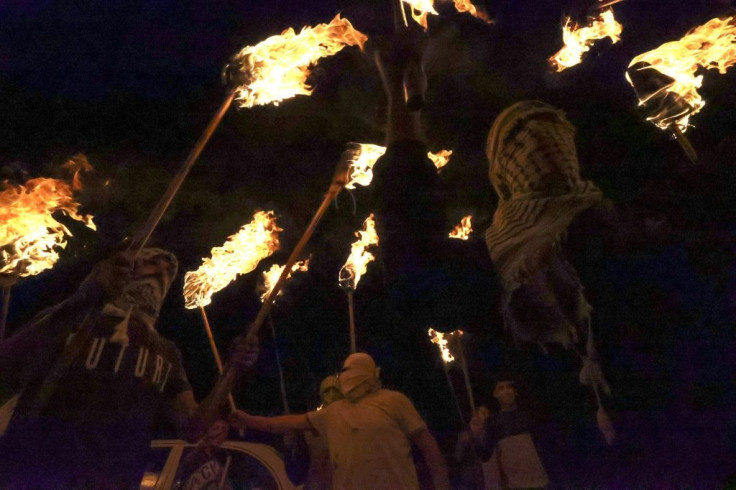 Palestinians carry torches during one of the nightly protests