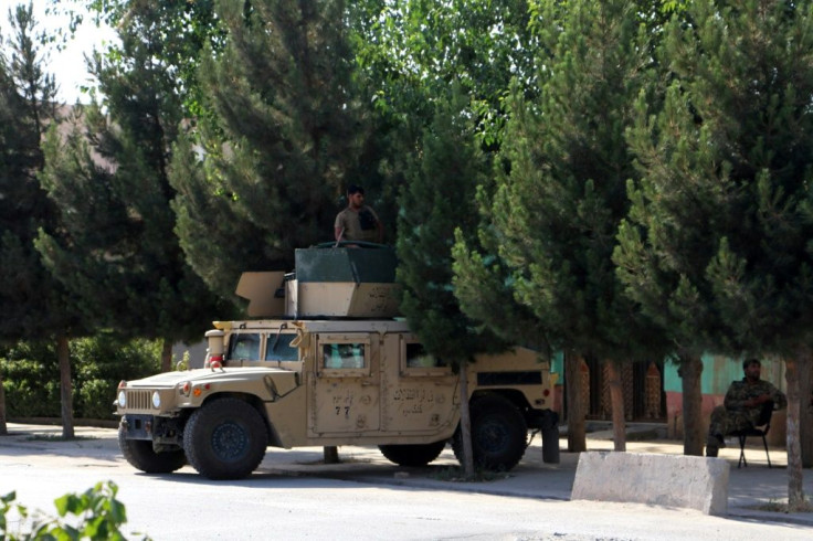 Afghan security forces stand guard on a Humvee vehicle along a roadside in Kunduz on Tuesday
