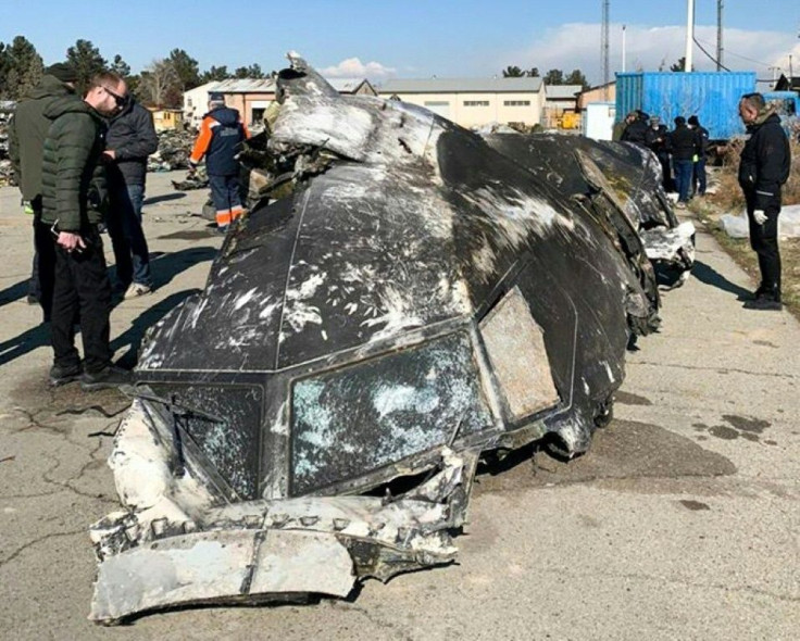 Handout photograph taken and released on January 11, 2020, by The National Security and Defense Council of Ukraine, shows people standing and analysing the fragments and remains of the Ukrainian plane downed by an Iranian missile outside the Tehran on Jan