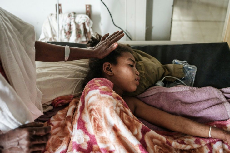 Genet Tsegay, 12, who was injured in a deadly airstrike on a market, is comforted by her mother at the Ayder referral hospital in Mekele