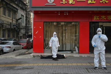 This photo by Hector Retamal shows officials in protective suits checking on an elderly man who collapsed and died on a street in Wuhan last year during the Chinese city's Covid-19 outbreak