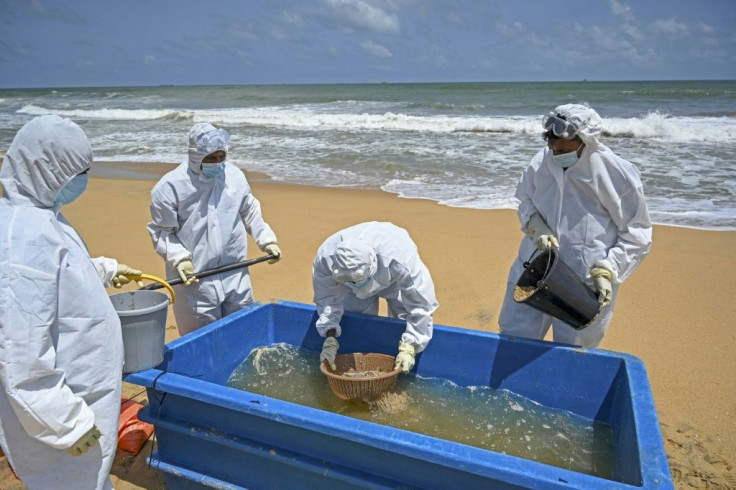 Members of the Sri Lankan Navy work to remove debris washed ashore from the Singapore-registered container ship MV X-Press Pearl