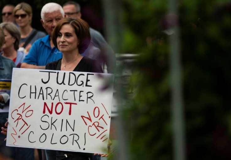 A woman holds up a sign at a rally against teaching "critical race theory" in schools, in Leesburg, Virginia on June 12, 2021