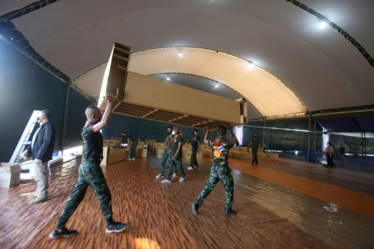 Soldiers carry a makeshift cardboard bed during the establishment of a new field hospital in Pattani, Thailand