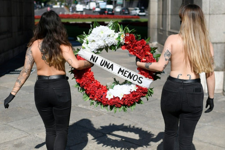 Topless activists in Madrid holding a wreath reading 'Not one less' during a protest against domestic violence towards women in June 2020.