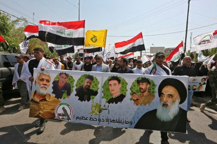 Mourners march with a banner showing (L to R) Iraq's slain Hashed al-Shaabi commander Abu Mahdi al-Muhandis, other slain members of the group and Iraq's top Shiite cleric Grand Ayatollah Ali al-Sistani, during a symbolic funeral in the Iraqi capital