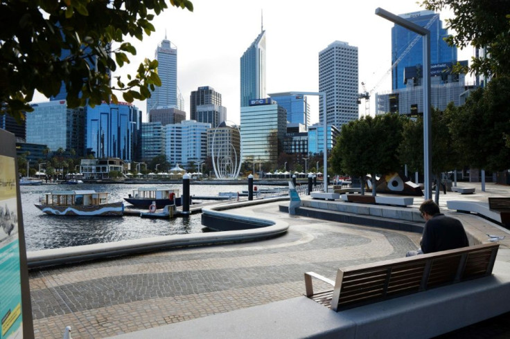 A man sits on a bench in a deserted Elizabeth Quay in Perth, which is locked down