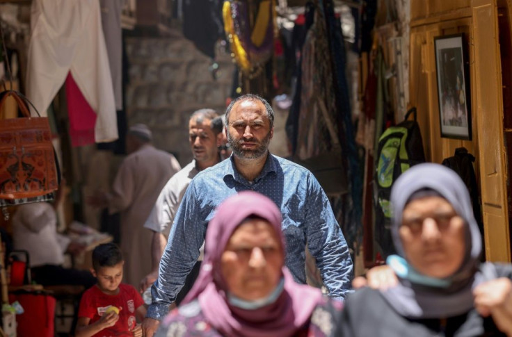Palestinian human rights activist Issa Amro walks through the market of Hebron's old city in the occupied West Bank, on June 27