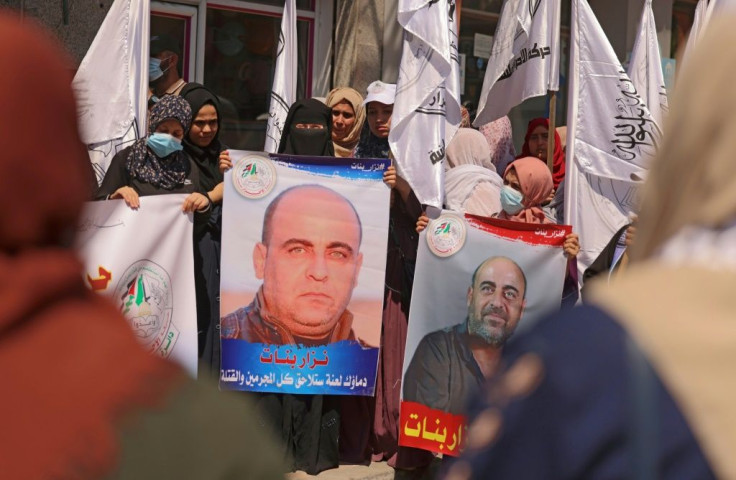 Women hold up posters depicting late Palestinian human rights activist Nizar Banat during a Gaza City protest days after he died during a violent arrest