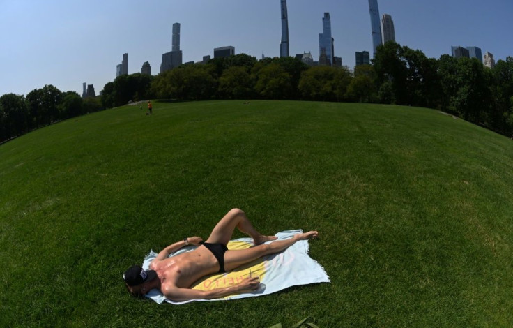 A man lays in the Sheep Meadow in Central Park in New York, on June 29, 2021 as New Yorkers brace for heat and humidity
