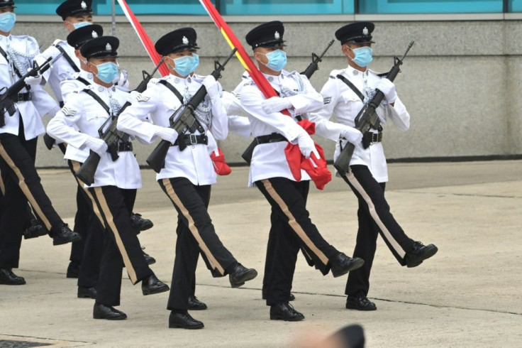 Hong Kong Police officers goose-step carrying the Chinese and Hong Kong flags during a flag-raising ceremony