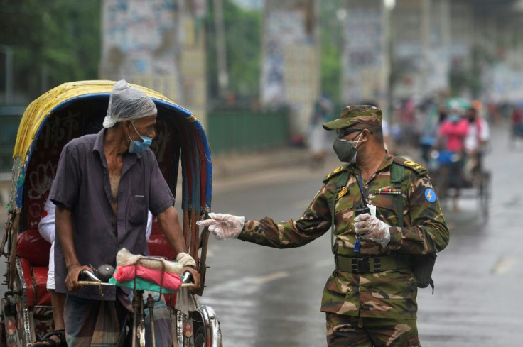 Bangladesh army personnel question a man commuting on a rickshaw at a checkpoint in Dhaka