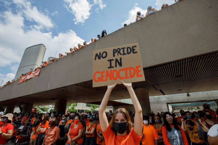 People hold signs and gather during the Every Child Matters walk in honour of indigenous children who lost their lives in Canada's residential school system, in Toronto, Canada, on July 1, 2021