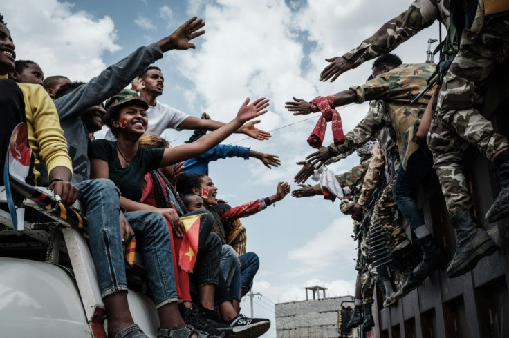 People on a bus reach out to the returning rebels in Mekele