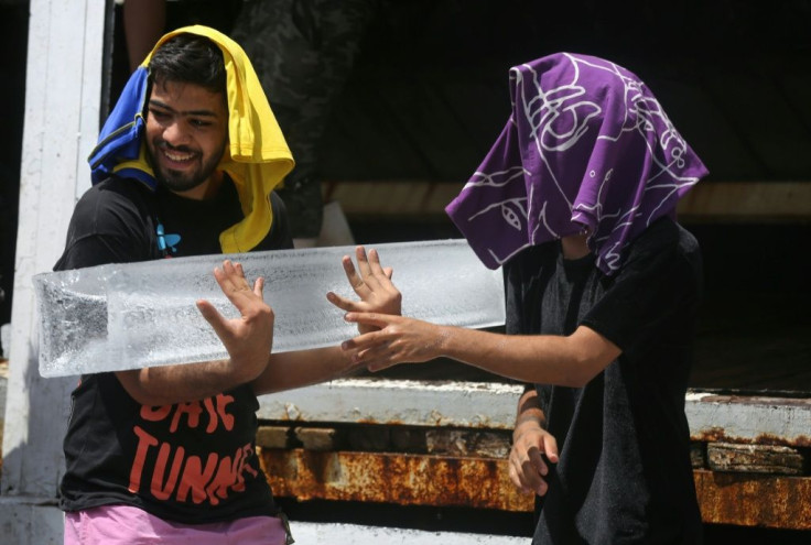 Iraqi youths buy ice blocks at a factory in the Baghdad district of Sadr City