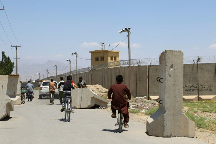 Children ride bicycles past a road checkpoint outside Bagram Air Base, after all US and NATO troops left