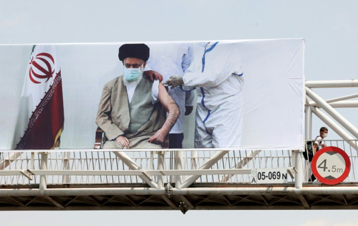 An overpass in Tehran bears a banner showing Iran's supreme leader Ayatollah Ali Khamenei receiving a Covid vaccine